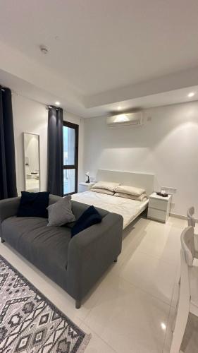 une grande chambre avec un lit et un canapé dans l'établissement 1 Hawana VIP Studio, à Salalah