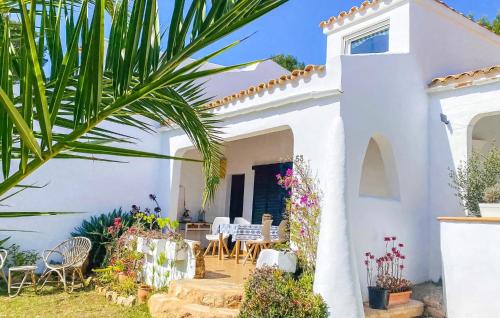 ein weißes Haus mit einem Garten davor in der Unterkunft Casarena in Cala d´Or