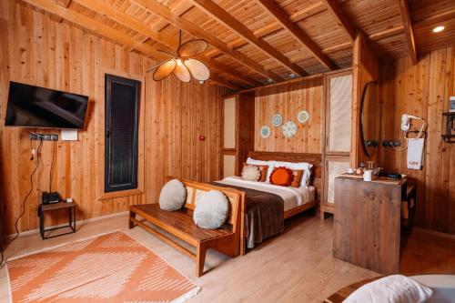 a bedroom with a bed and a chair and a tv at Lov Faralya Adults Only in Faralya
