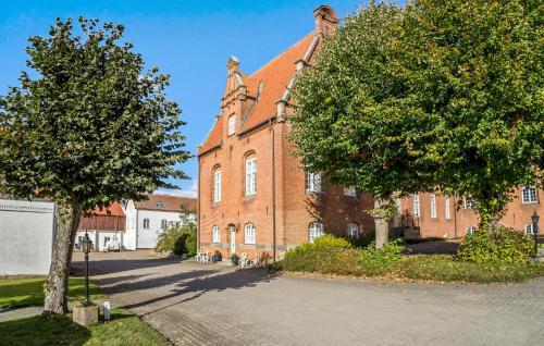 a large brick building with a tree in front of it at Lejl 51 in Skanderborg