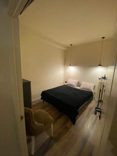 a bedroom with a black bed and a chair at Menechyan's Apartment in Yerevan
