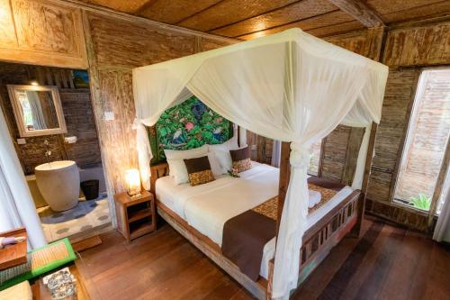 Un pat sau paturi într-o cameră la Royal JJ Ubud Resort & Spa