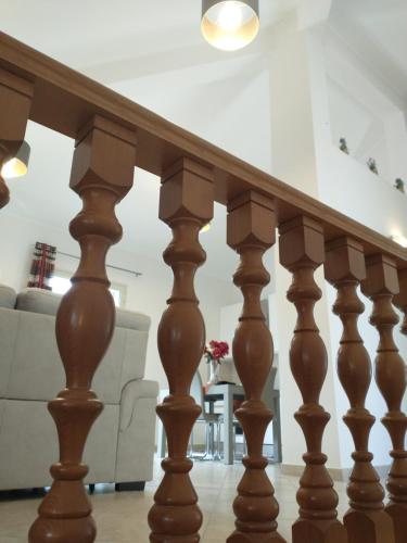 a wooden stair railing in a living room with a couch at Carini house in Carini