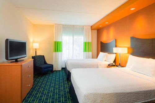 a hotel room with two beds and a flat screen tv at Fairfield Inn & Suites Huntingdon Raystown Lake in Huntingdon