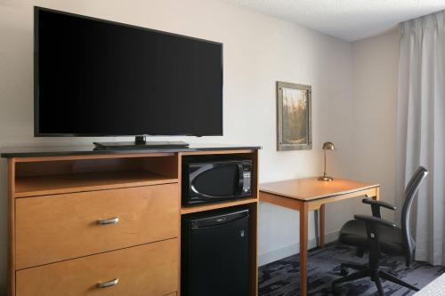 a hotel room with a television on a dresser with a desk at Fairfield Inn Manhattan, Kansas in Manhattan