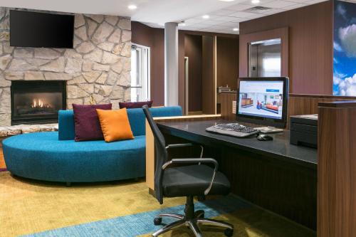 a living room with a blue couch and a fireplace at Fairfield Inn Manhattan, Kansas in Manhattan