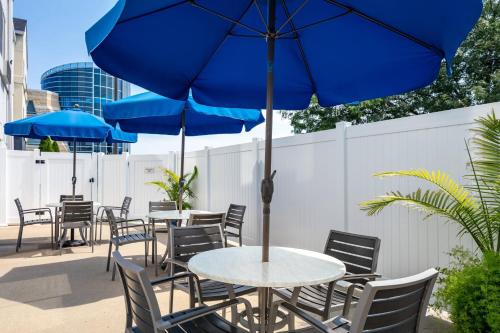 a patio with tables and chairs with blue umbrellas at Fairfield Inn Manhattan, Kansas in Manhattan