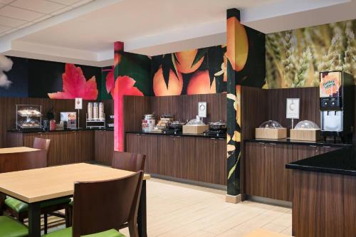 a restaurant with a table and chairs and a counter at Fairfield Inn Manhattan, Kansas in Manhattan