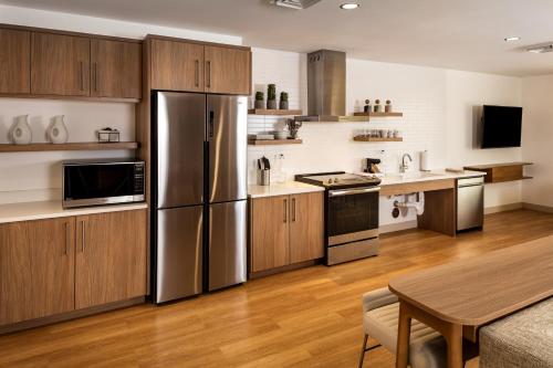 a kitchen with stainless steel appliances and wooden cabinets at Element Bend in Bend