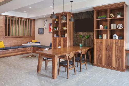 a dining room with a wooden table and chairs at Four Points by Sheraton Chicago Schaumburg in Schaumburg