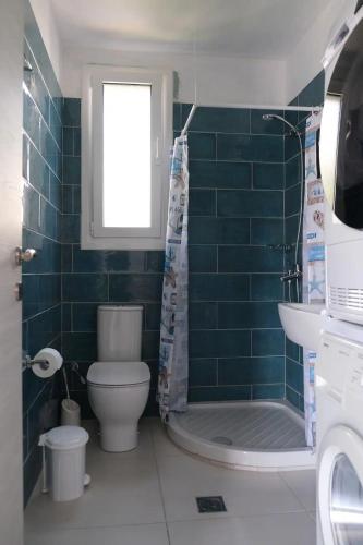 a bathroom with a toilet and a shower and a sink at Kassandra in Syvota
