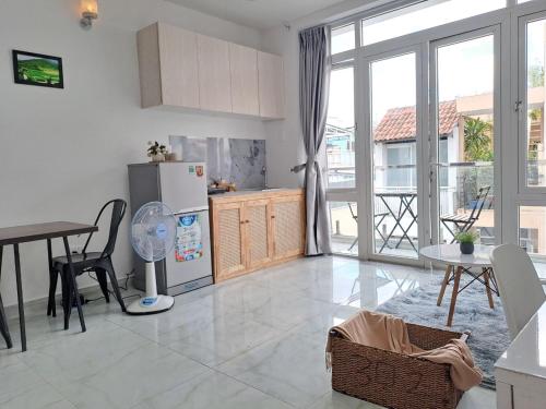 a kitchen and dining room with a table and a refrigerator at Cozy studio at Hai Ba Trung st., Dist 3 near Tan Dinh market in Ho Chi Minh City
