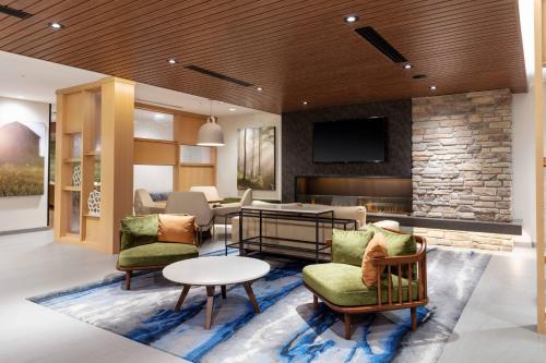 a lobby with chairs and a table and a tv at Fairfield by Marriott Inn & Suites Medford in Medford