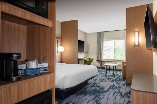 a hotel room with a bed and a television at Fairfield by Marriott Inn & Suites Medford in Medford