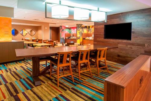 a dining room with a large wooden table and chairs at Fairfield Inn & Suites by Marriott San Antonio Brooks City Base in San Antonio