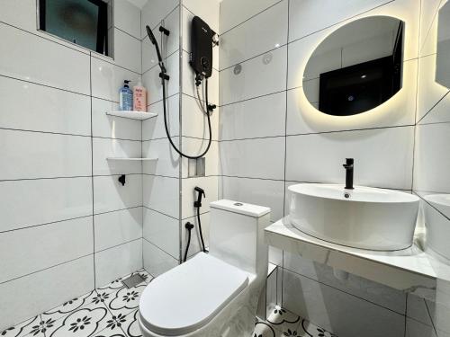 a white bathroom with a toilet and a sink at Century Suria Aparment Langkawi by Zervin in Kuah