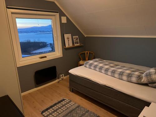 a bedroom with a bed and a window at Exclusive view villa in Tromsø