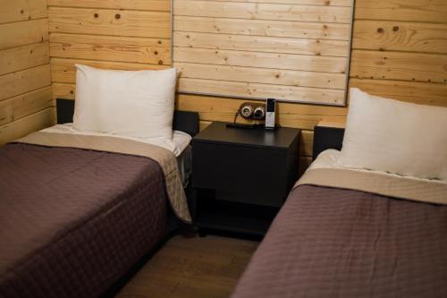 a room with two beds and a table with a telephone at Готель Logindariy in Rokosovo
