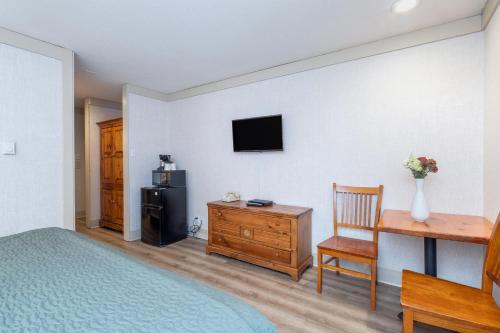 a bedroom with a bed and a desk and a television at Mountainside Inn 201 by Alpine Lodging Telluride in Telluride