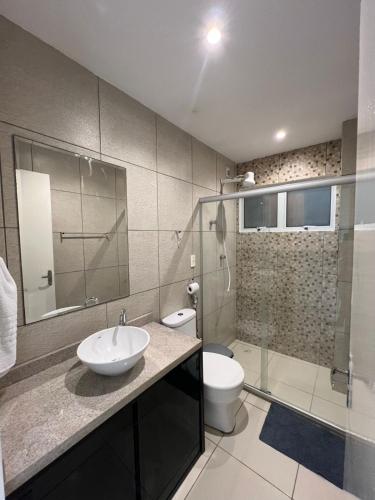 a bathroom with a sink and a toilet and a shower at Apartamento Pé na areia no condomínio Manga Verde in Itamaracá
