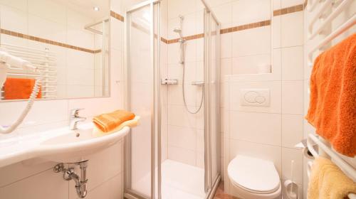 uma casa de banho com um chuveiro, um lavatório e um WC. em Pension Steiermark em Schladming