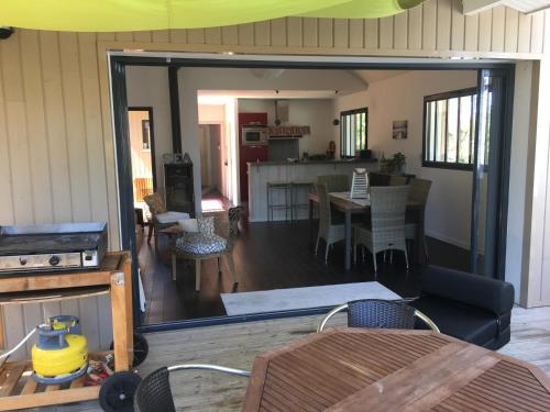 un salon avec une table et une salle à manger dans l'établissement Villa LACANAULAISE, à Lacanau