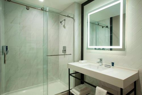 a bathroom with a sink and a shower with a mirror at Four Points by Sheraton Manhattan Midtown West in New York