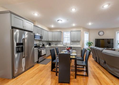 a kitchen with a table with chairs and a refrigerator at 233-1 4BR Boston - Cozy Apt near MBTA Station in Boston