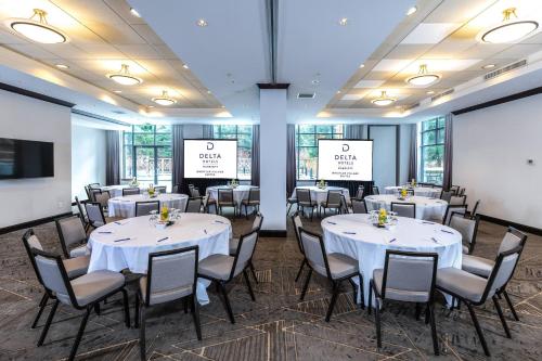 a banquet room with white tables and chairs and screens at Delta Hotels by Marriott Whistler Village Suites in Whistler