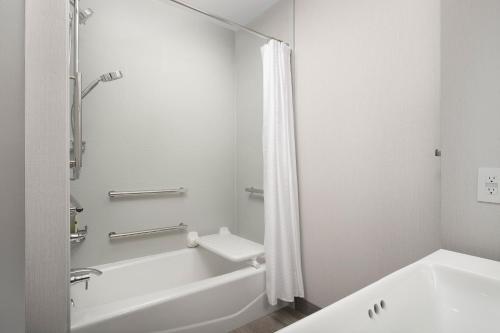 a white bathroom with a tub and a sink at Element Seattle Sea-Tac Airport in Tukwila