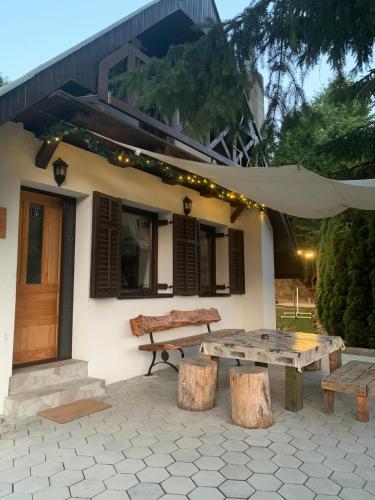 a picnic table and bench in front of a house at Vila Krnjević Jastrebac in Buci