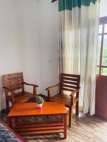 a living room with two chairs and a table and a window at Top Heaven in Ella