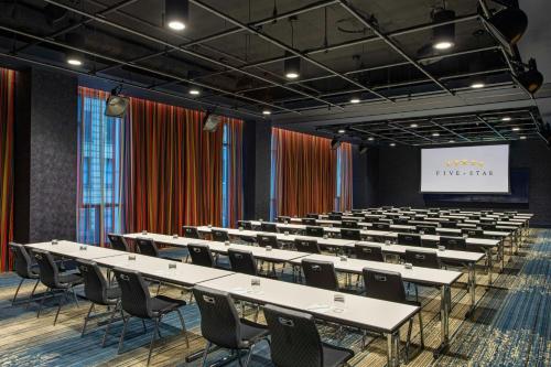 a lecture hall with tables and chairs and a screen at Element Philadelphia Downtown in Philadelphia