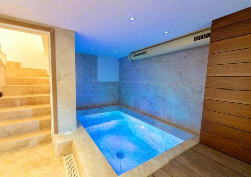 - une grande baignoire bleue dans une chambre avec des escaliers dans l'établissement Maison luxueuse en montagne avec piscine chauffée, à Beuil