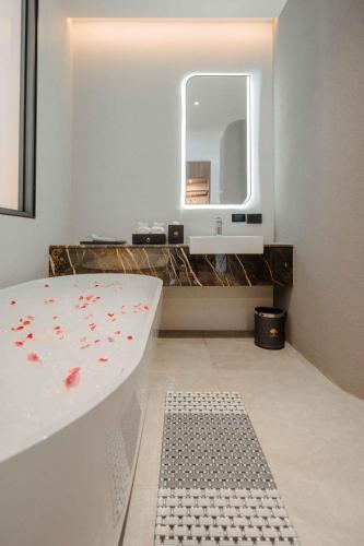 a bathroom with a bath tub and a mirror at Richmann Resort Hotel Hatyai in Hat Yai