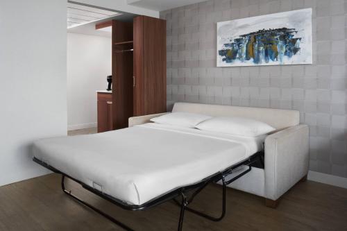 a white bed in a room with a painting on the wall at Delta Hotels by Marriott Trois Rivieres Conference Centre in Trois-Rivières