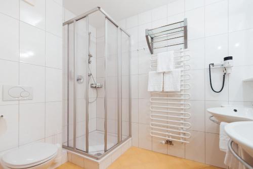 a bathroom with a shower and a toilet and a sink at Hotel Schneider Dependance in Obertauern