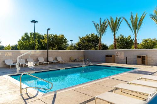 a swimming pool with lounge chairs next to a building at Element Sacramento Airport in Sacramento