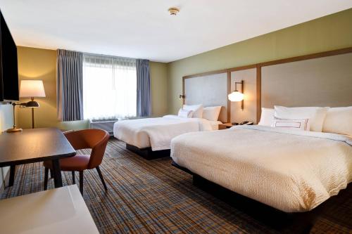 a hotel room with two beds and a desk at Fairfield Inn & Suites by Marriott Milwaukee North in Glendale