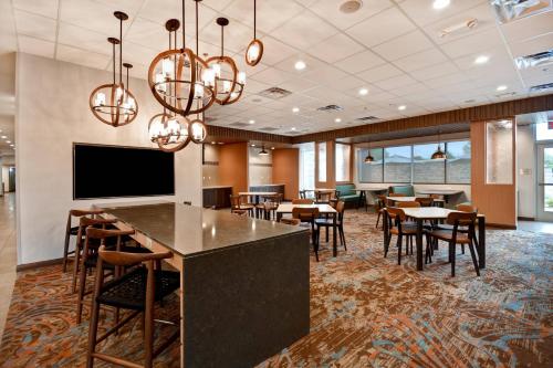 a conference room with tables and chairs and a flat screen tv at Fairfield Inn & Suites by Marriott Milwaukee North in Glendale