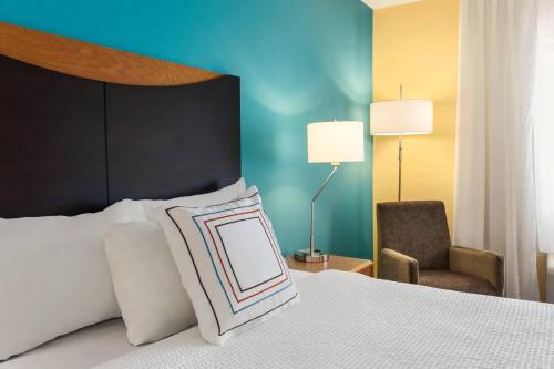 a bedroom with a bed with a pillow and a chair at Fairfield Inn & Suites by Marriott Norman in Norman