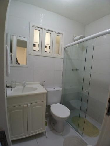 a bathroom with a toilet and a sink and a shower at CHALÉS ENCANTOS DA ILHA in Barra dos Coqueiros
