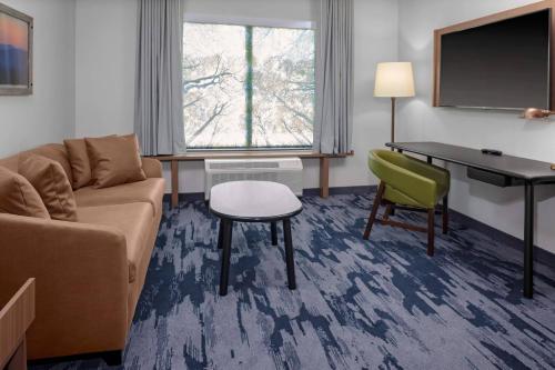 a living room with a couch and a table and a desk at Fairfield Inn & Suites by Marriott Memphis Collierville in Collierville