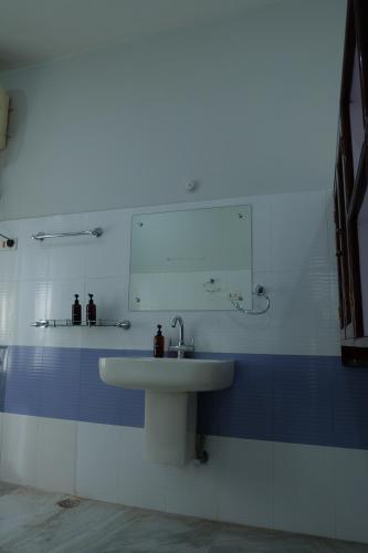 un baño con lavabo y espejo en JOY'S BNB, en Imphal
