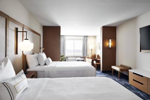 a hotel room with two beds and a television at Fairfield Inn & Suites Sheboygan in Sheboygan