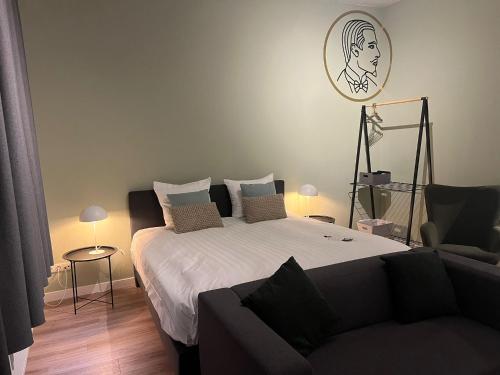 a bedroom with a large bed and a couch at Alex Maastricht in Maastricht