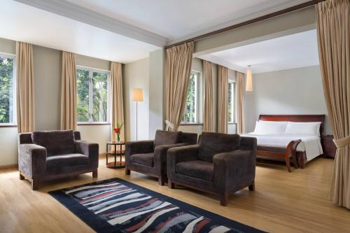 a hotel room with a bed and two chairs at Four Points by Sheraton Arusha, The Arusha Hotel in Arusha