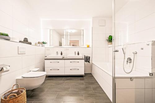 een witte badkamer met een toilet en een wastafel bij Apartment Nautilus in Seenähe in Friedrichshafen