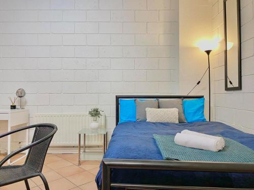 ein Schlafzimmer mit einem blauen Bett und einem Stuhl in der Unterkunft 504 Lovely Cosy Private Studio Apartment Central in Melbourne