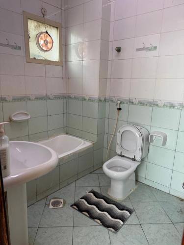 een badkamer met een wastafel, een toilet en een bad bij Stunning Corniche view in Ras al Khaimah